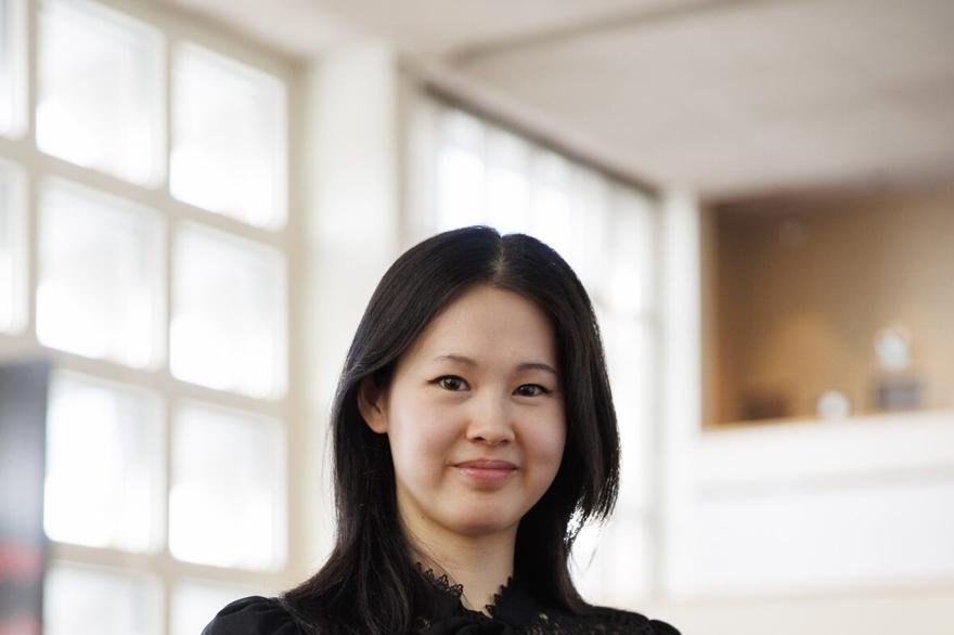 Conductor Monica Chen holding a baton.